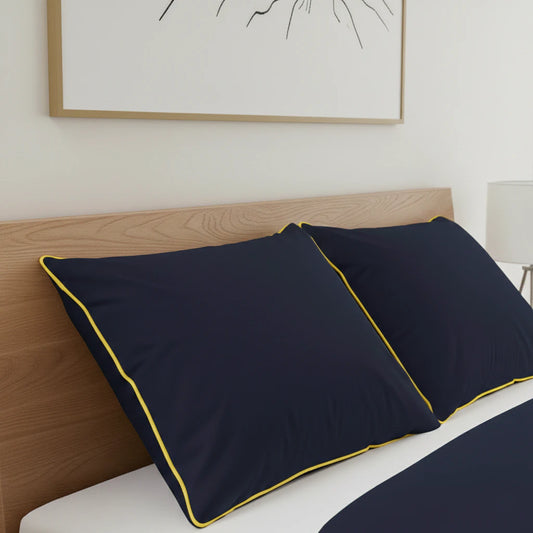 Sötétkék szatén ágynemű párnái közeről, tölgy franciaágyon