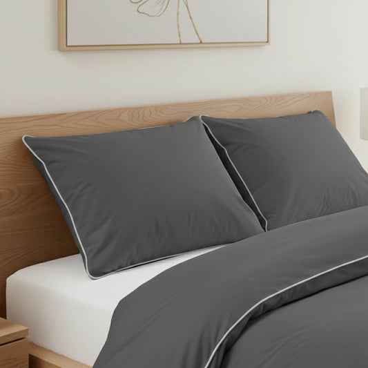 Szürke szatén luxus ágynemű párnái közelről