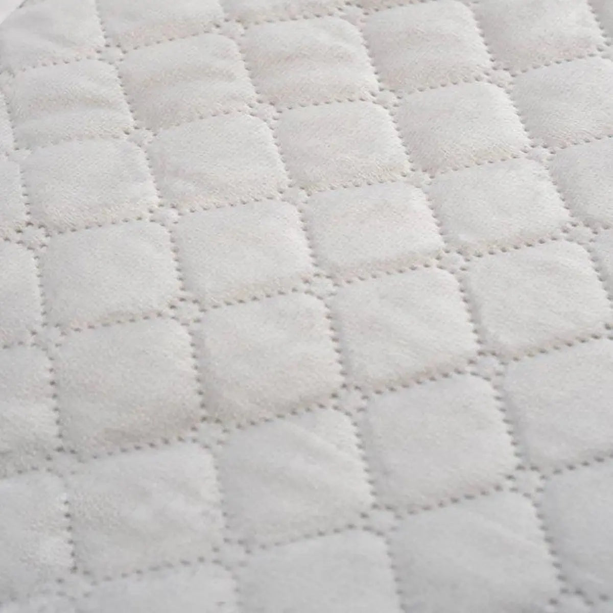 Szürke steppelt ágytakaró anyaga közelről