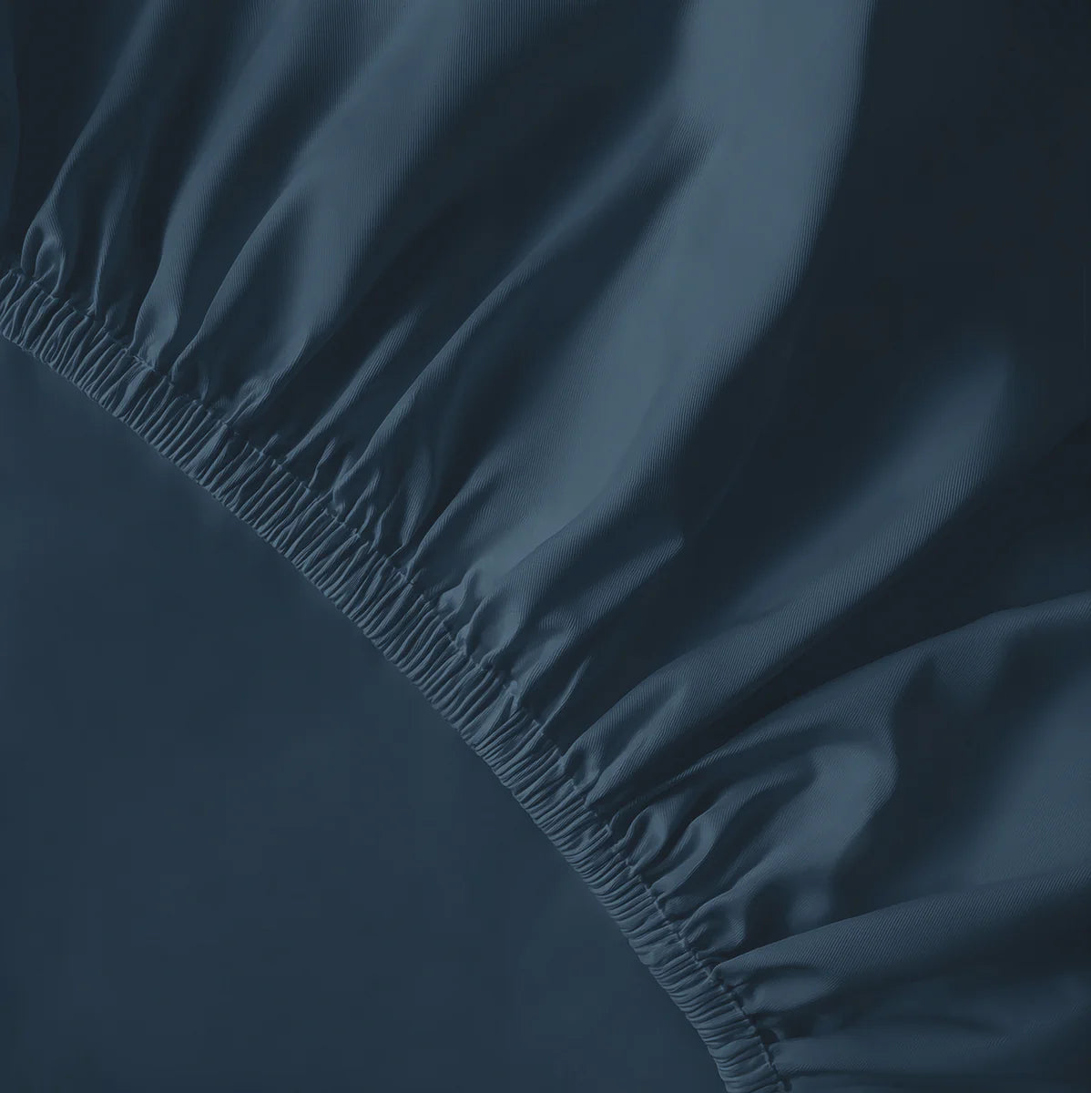 Sötétkék gumis lepedő sarka közelről