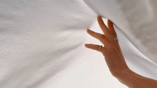 Ágyneműt magasba emelő női kéz