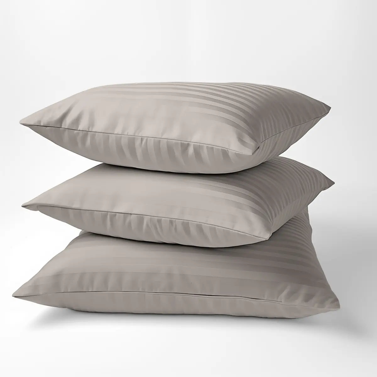 Három egymásra tett párna, bézs luxus ágyneműhuzat párnahuzatával